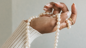 A string necklace of pearls in a hand.